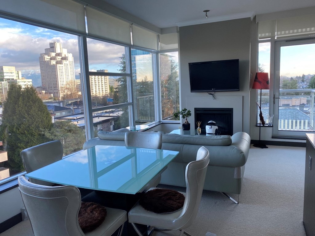 a living room with a glass table and a couch and a view of the city