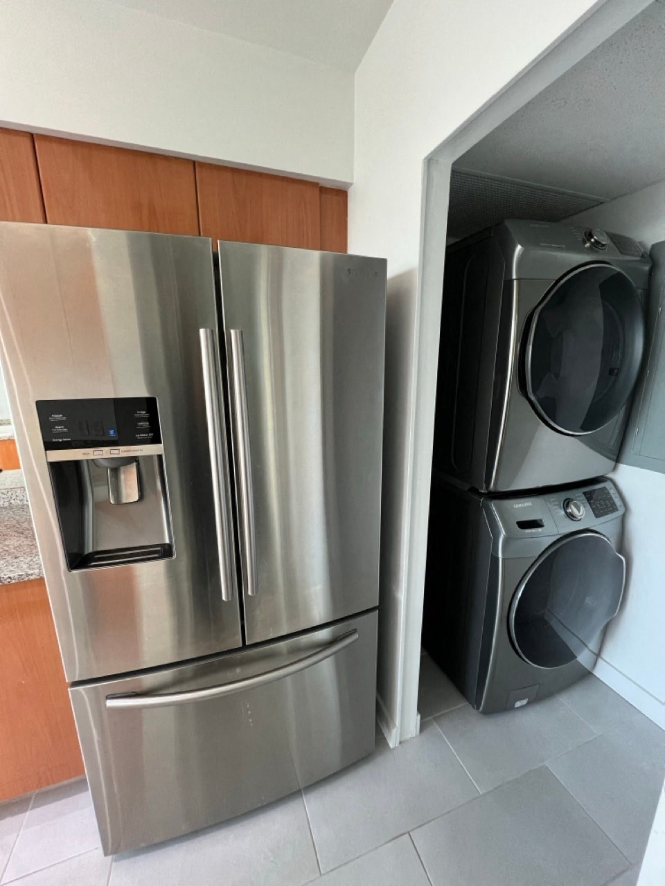 a stainless steel refrigerator and a washer and dryer in a kitchen
