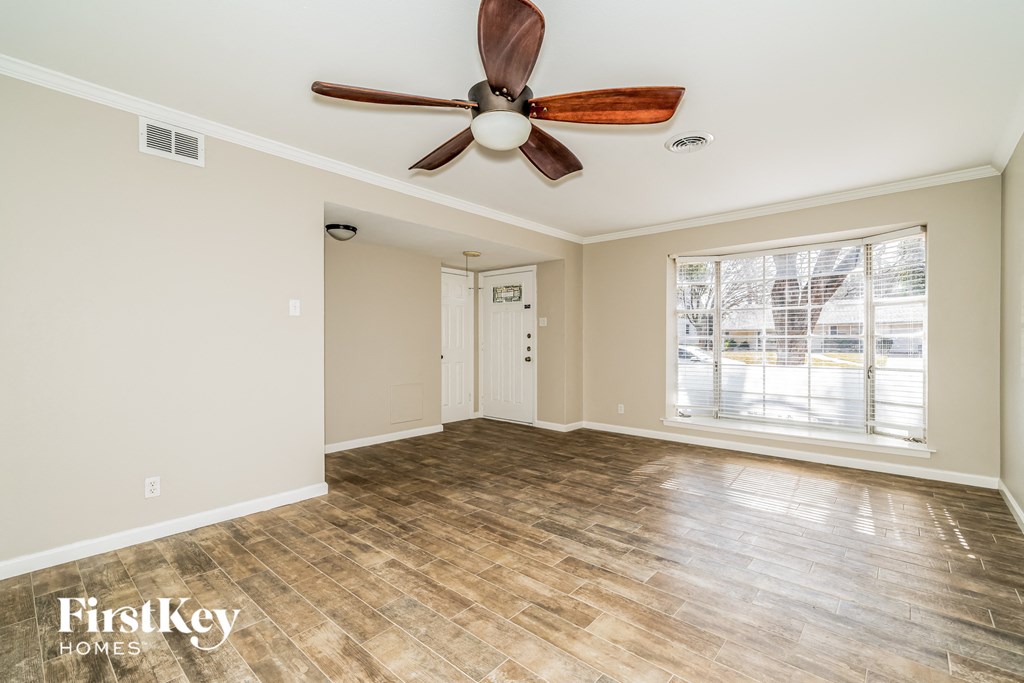 a living room with a ceiling fan and a window