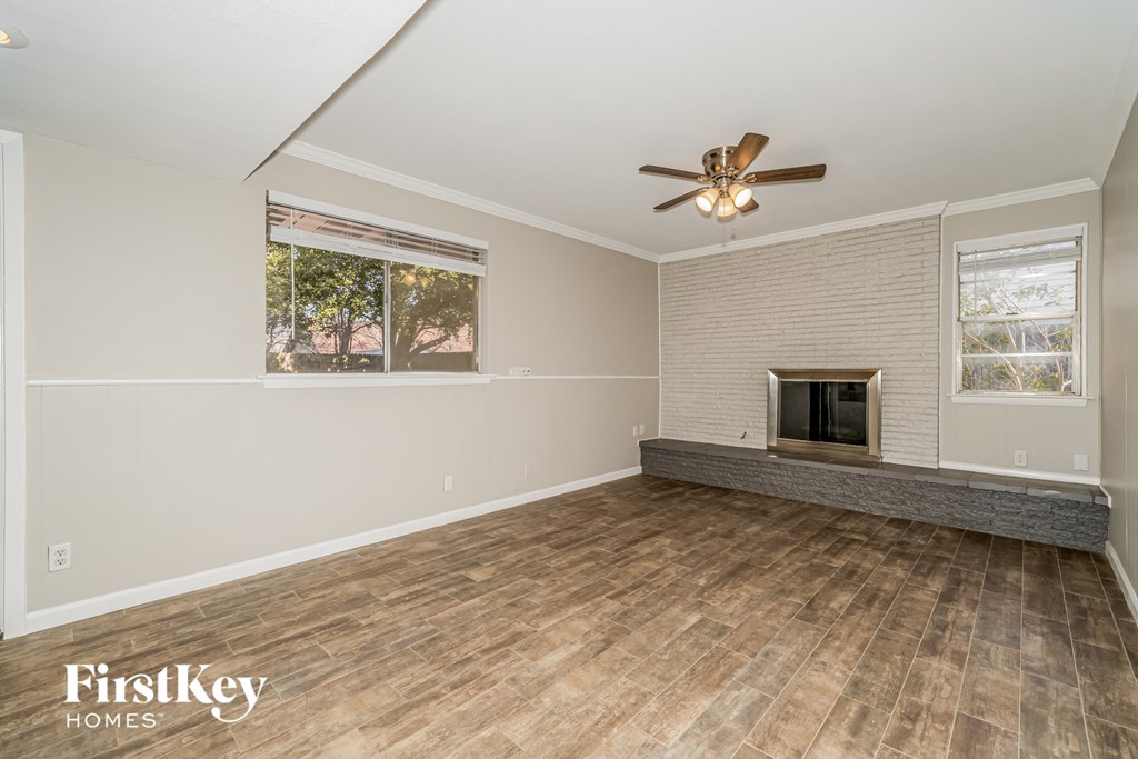 a living room with a fireplace and a ceiling fan
