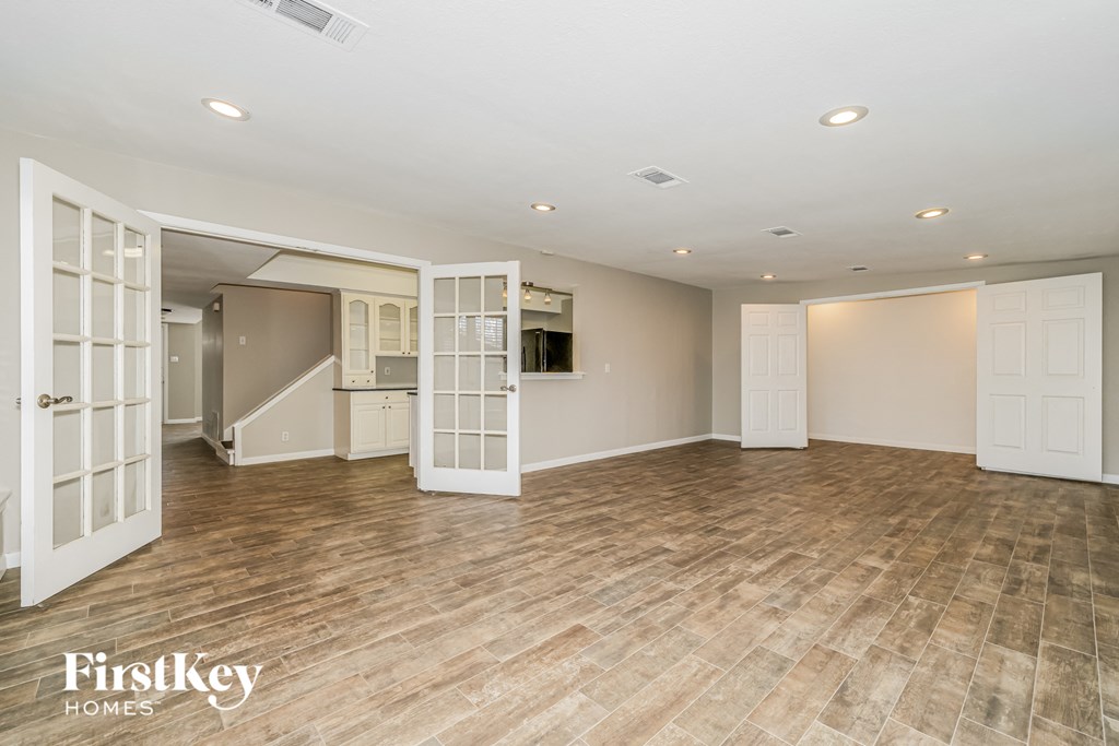 a living room with a hard wood floor and white doors