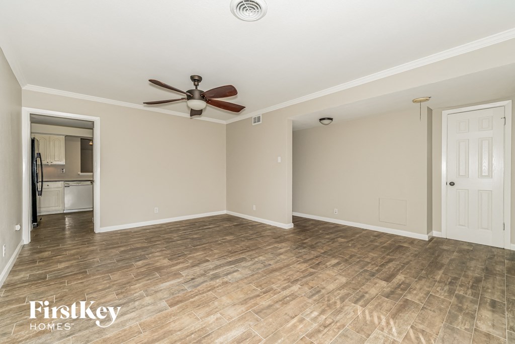 a living room with wood floors and a ceiling fan