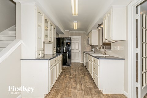 a large kitchen with white cabinets and a wood floor