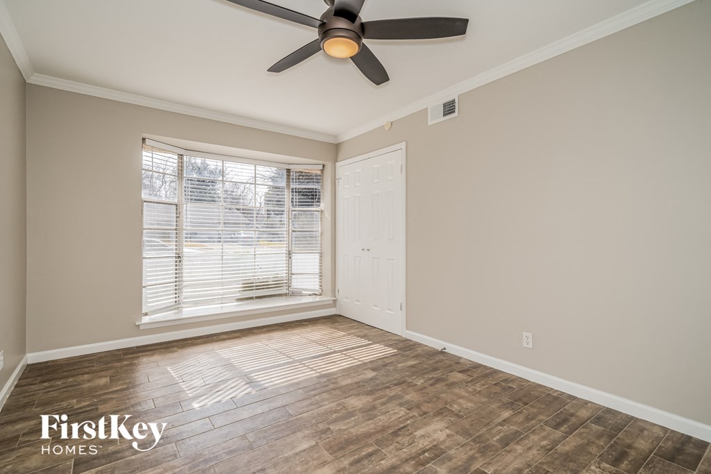 a living room with a ceiling fan and a window