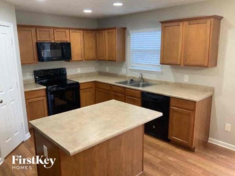 A kitchen with wooden cabinets and a marble countertop.