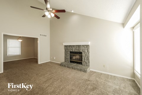 a living room with a fireplace and a ceiling fan