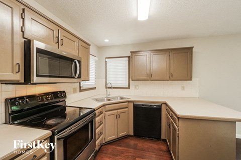 a kitchen with a stove and a sink and a microwave