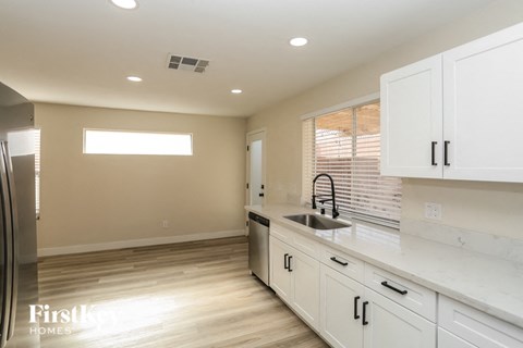 A kitchen with white cabinets and a sink.