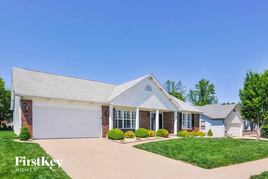 a white house with a white garage door and a lawn