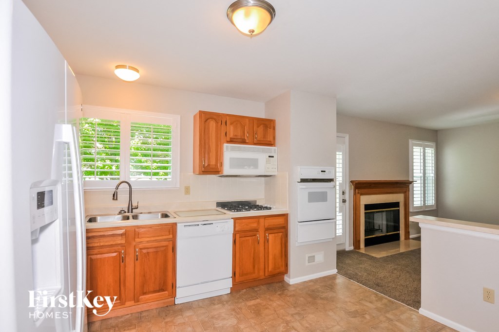 a kitchen with white appliances and wooden cabinets