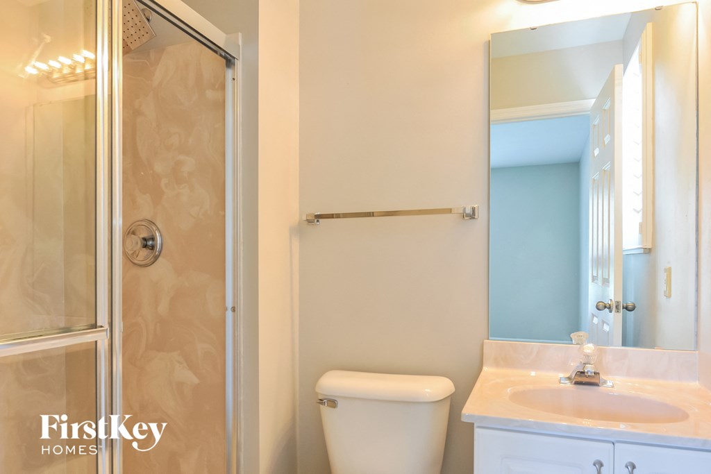 a bathroom with a toilet and a shower and a sink