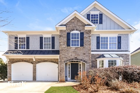a house with two white garage doors in front of it