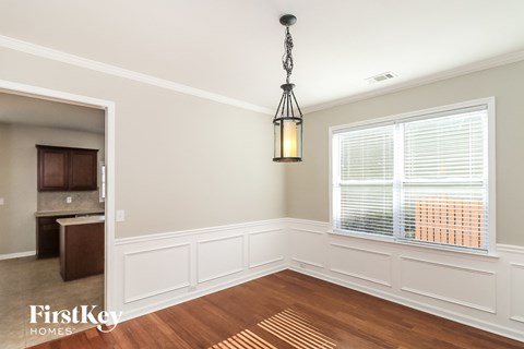 an empty dining room with a large window and a lamp