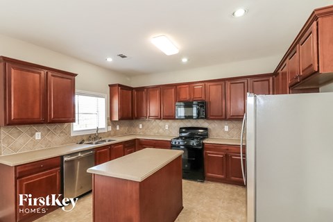 a kitchen with wooden cabinets and a stainless steel refrigerator
