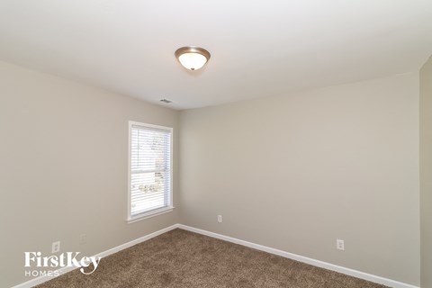 a bedroom with a carpeted floor and a window