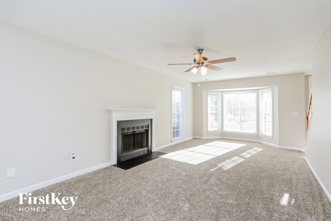 a living room with a ceiling fan and a fireplace