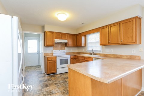 a kitchen with wooden cabinets and a white counter top