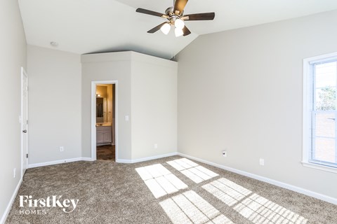 a living room with a ceiling fan and carpet
