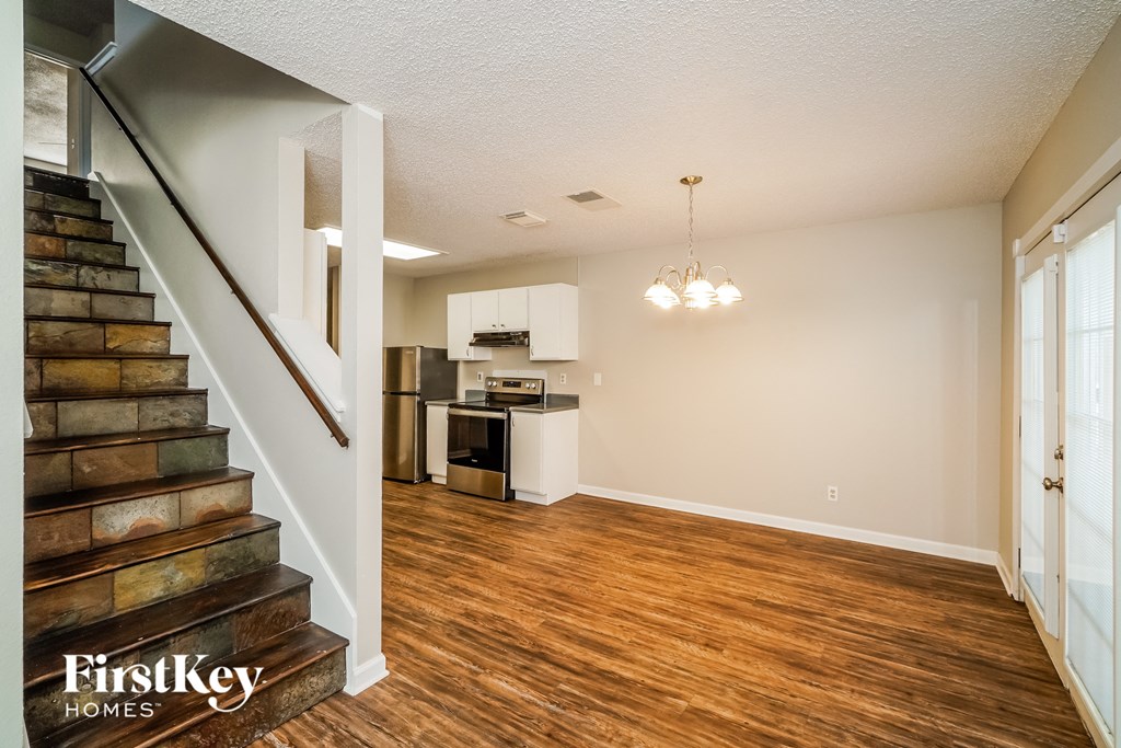 A room with wooden floors and a staircase leading to the upper floor.
