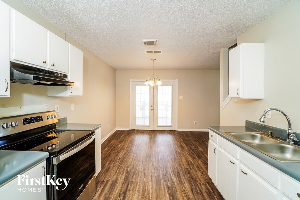 A kitchen with wooden floors and a stove top oven.