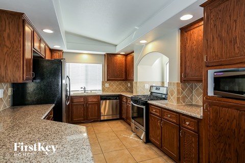 A kitchen with wooden cabinets and a black refrigerator.