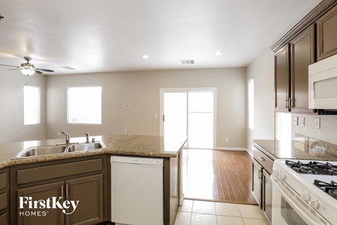 a kitchen with white appliances and granite counter tops
