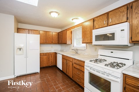 a kitchen with white appliances and wooden cabinets
