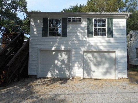 A white house with a garage door and a window.
