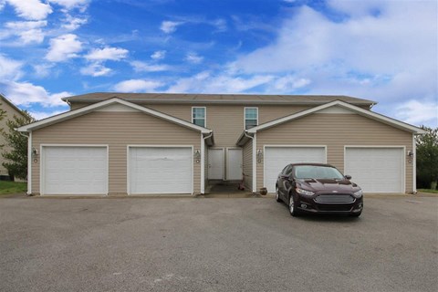 A car is parked in front of a two-car garage.