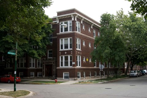 A red car is parked on the side of the street.