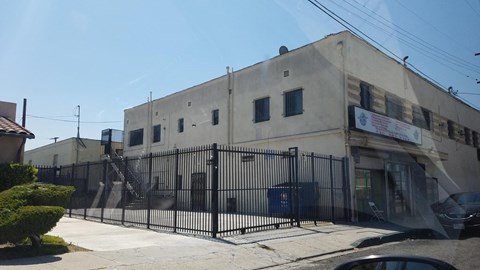 the front of a building with a fence and a gate