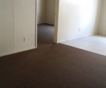an empty room with a carpeted floor and an open door