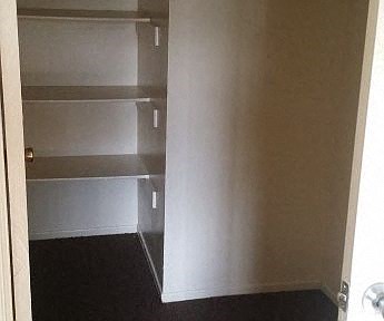 an empty room with white walls and a black floor