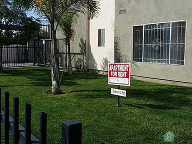 a red and white sign in the grass in front of a building