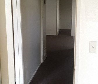 a hallway with an open door and a room with a door