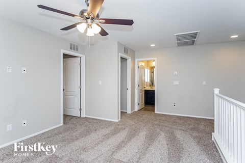 a living room with carpet and a ceiling fan