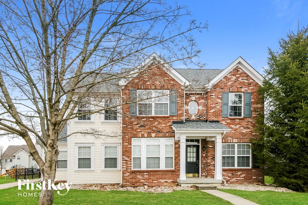 a brick house with a tree in front of it