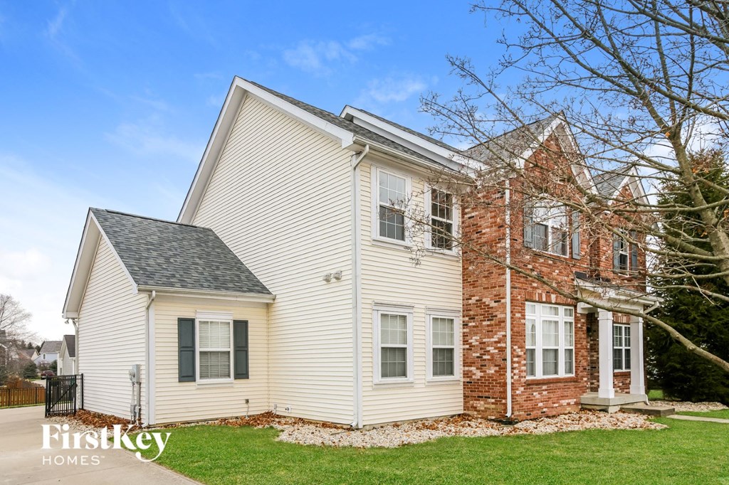 exterior view of a white house with red brick and white siding