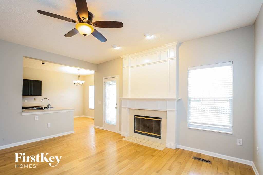 a living room with a fireplace and a ceiling fan