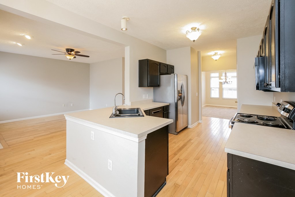 a kitchen with an island and a stove and a refrigerator