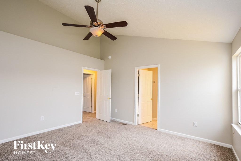 the master bedroom has a ceiling fan and carpeted flooring