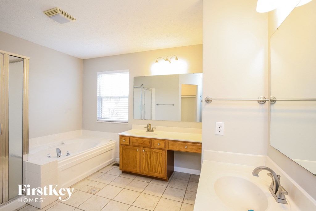 a bathroom with a tub and a sink and a mirror