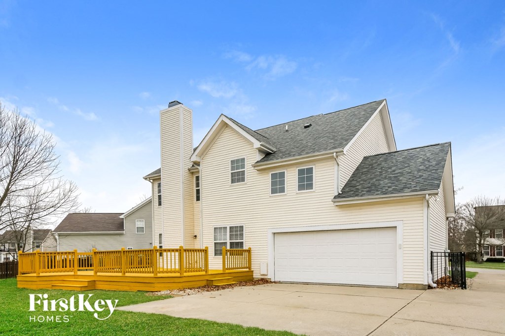 a home with a yellow deck and a white house