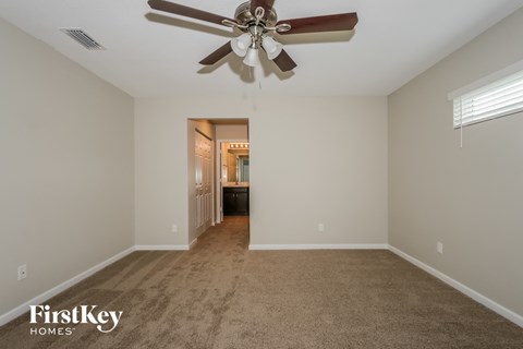 a living room with carpet and a ceiling fan