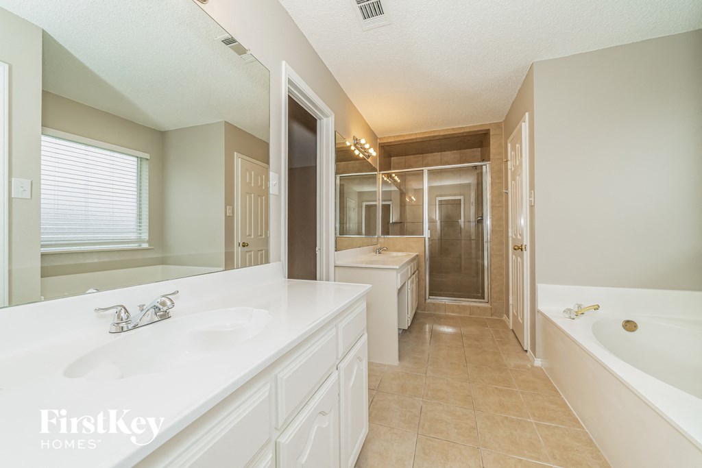 a bathroom with a sink and a tub and a shower