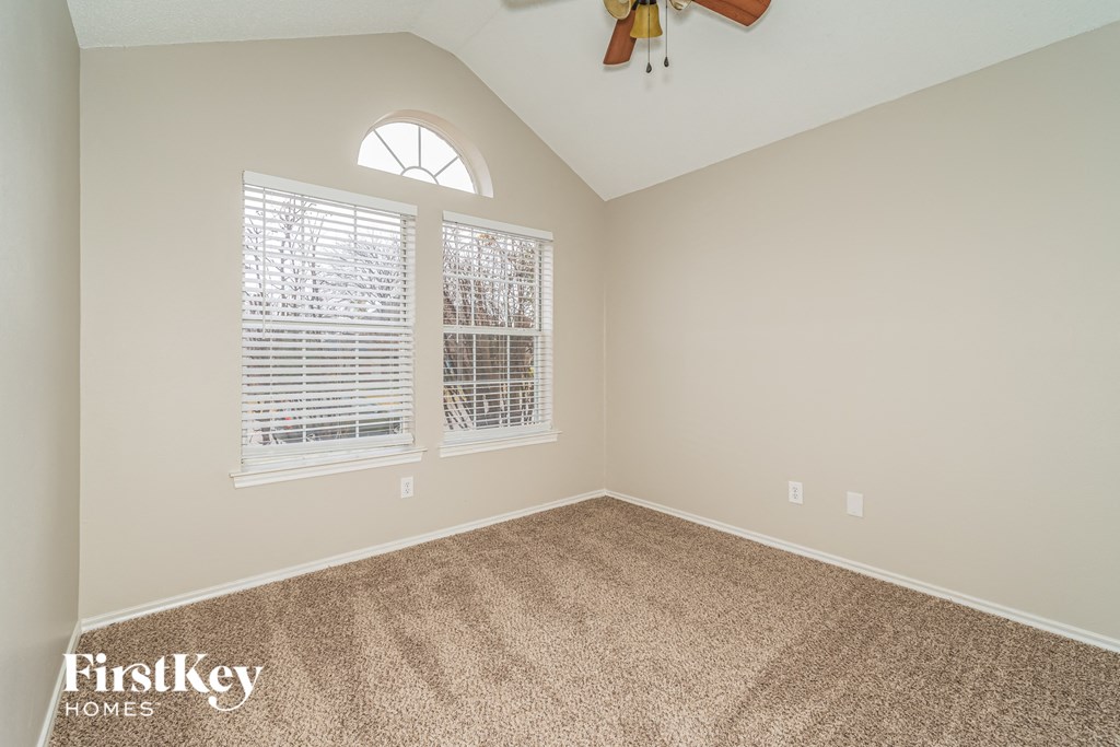 the second bedroom has a ceiling fan and a large window