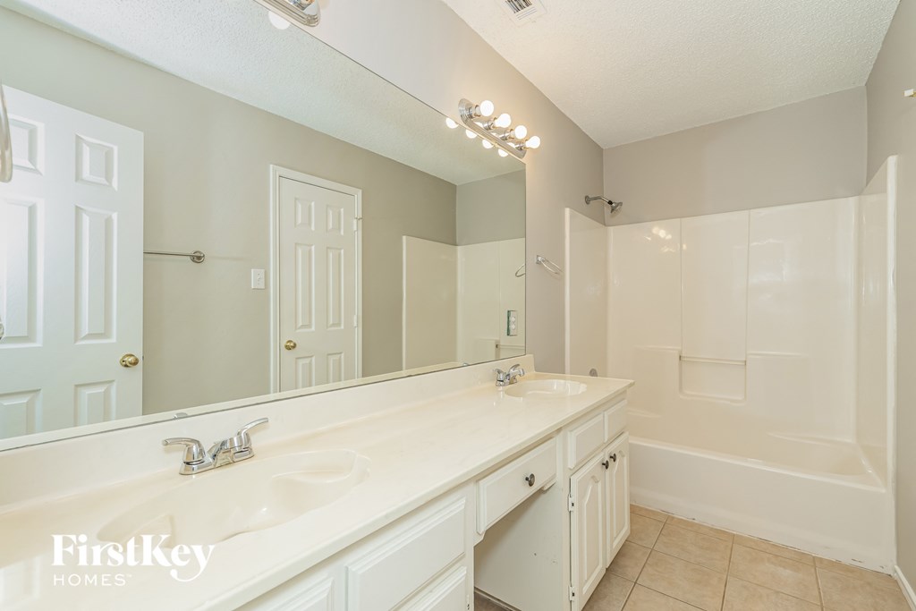 a bathroom with a large mirror and a large sink and a shower