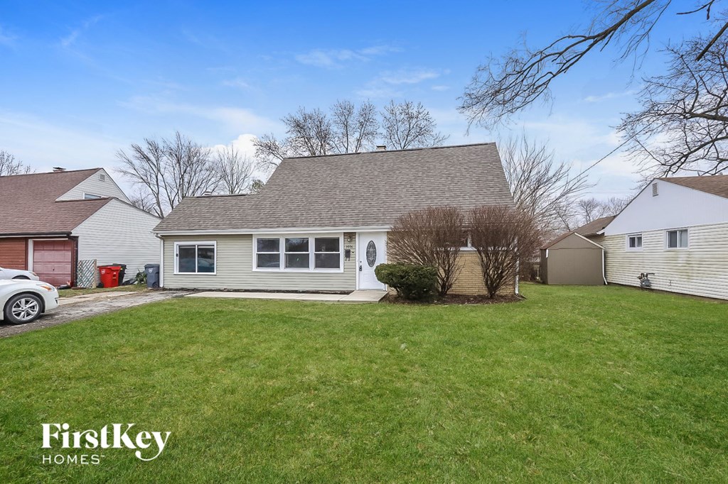 a white house with a yard and a car in front of it