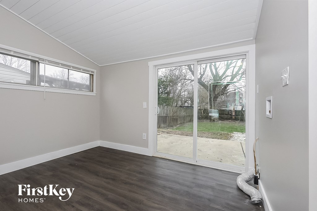 the living room of a home with a large window and a door to the backyard