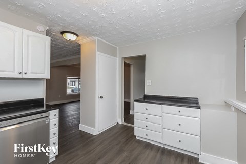 a kitchen with white cabinets and black counter tops